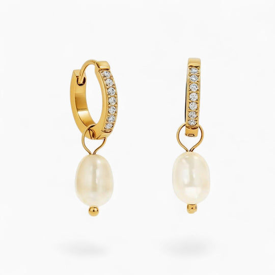 A pair of gold-colored hoop earrings with freshwater pearl charms attached, displayed against a white background.